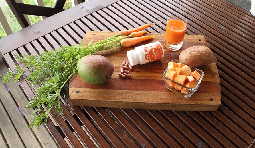 Betacarotene capsules, carrots, mango and sweet potatoes.