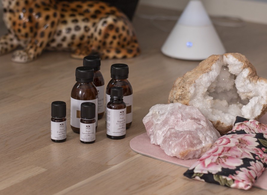 Pure Cedar oil and other essential oils stand on the floor in front of the aroma lamp.